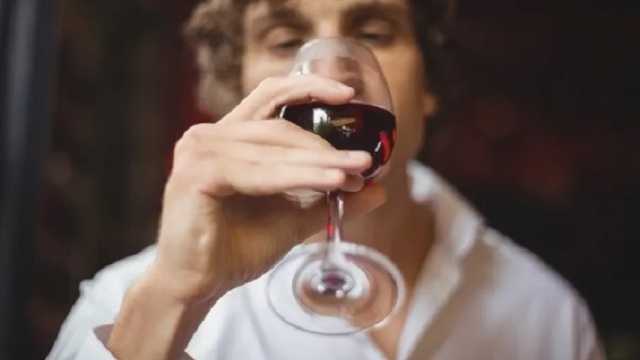 Hombre joven bebiendo copa de vino tinto. (Foto: Freepik)